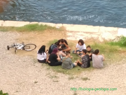 Grupo de adolescentes sentados junto al Río Ebro (Zaragoza)