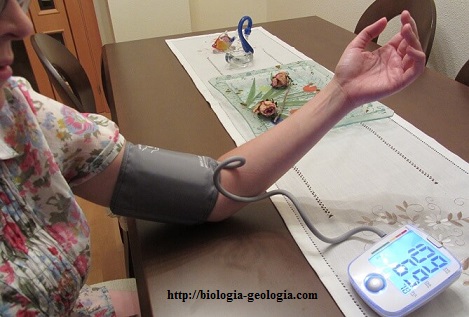 Mujer midiéndose su tensión arterial con un tensiómetro.